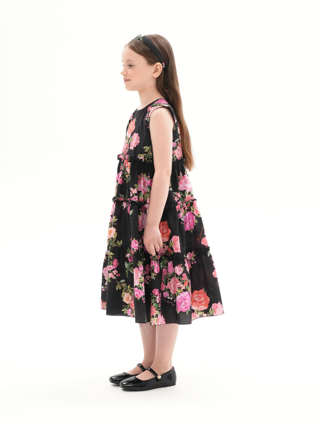 ALISA, A CHILDREN'S DRESS IN BLACK ADORNED WITH MEDIUM-SIZED PINK FLOWERS.