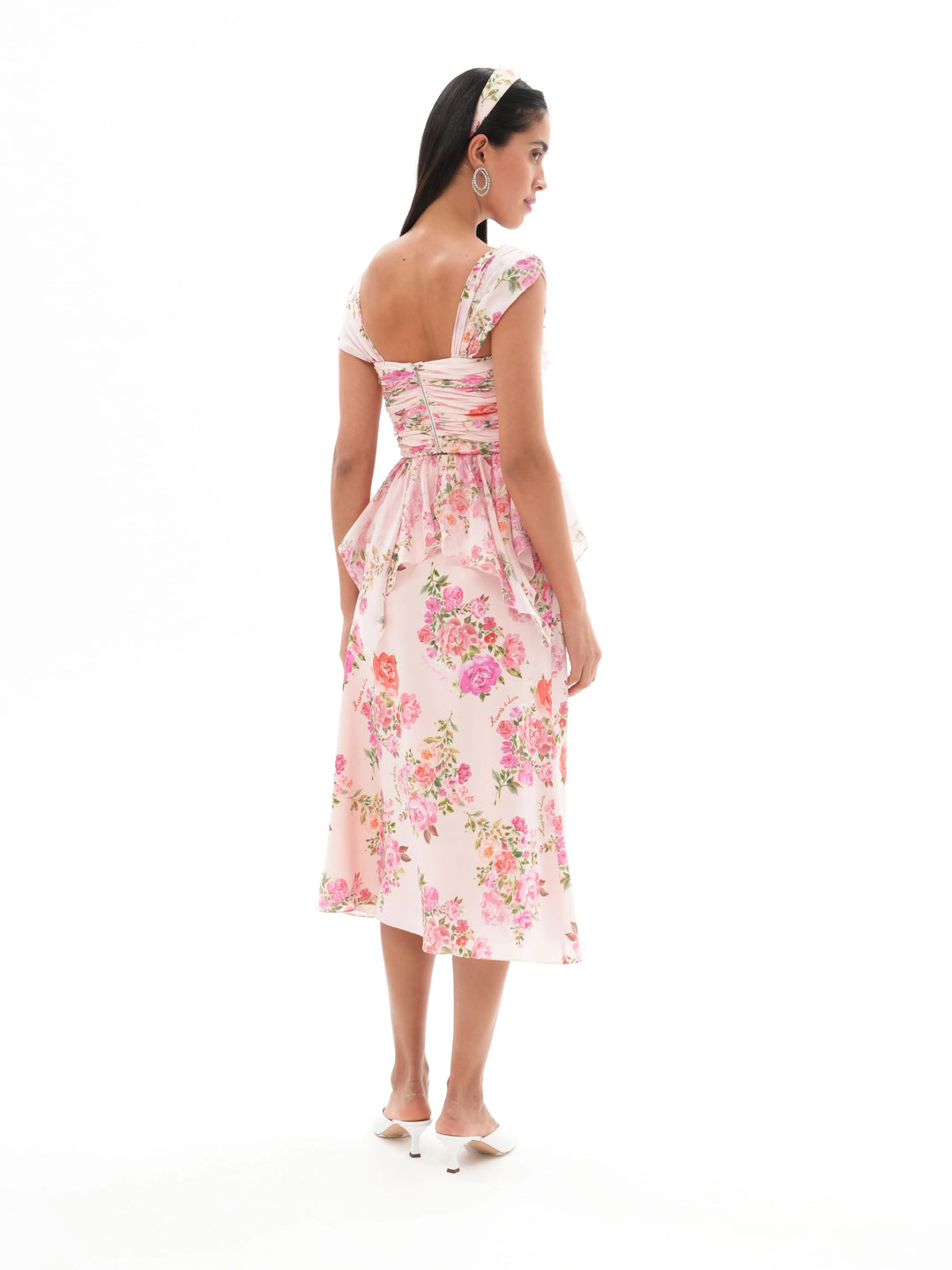 JEAN, A BABY PINK CORSET TOP WITH AN ASYMMETRICAL PEPLUM, ADORNED WITH MEDIUM-SIZED PINK FLOWERS