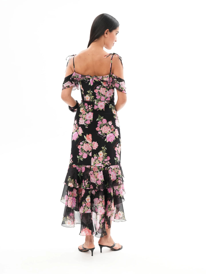 MONICA, A BLACK MAXI DRESS WITH SHORT SLEEVES AND RUFFLES, ADORNED WITH MEDIUM-SIZED PINK FLOWERS