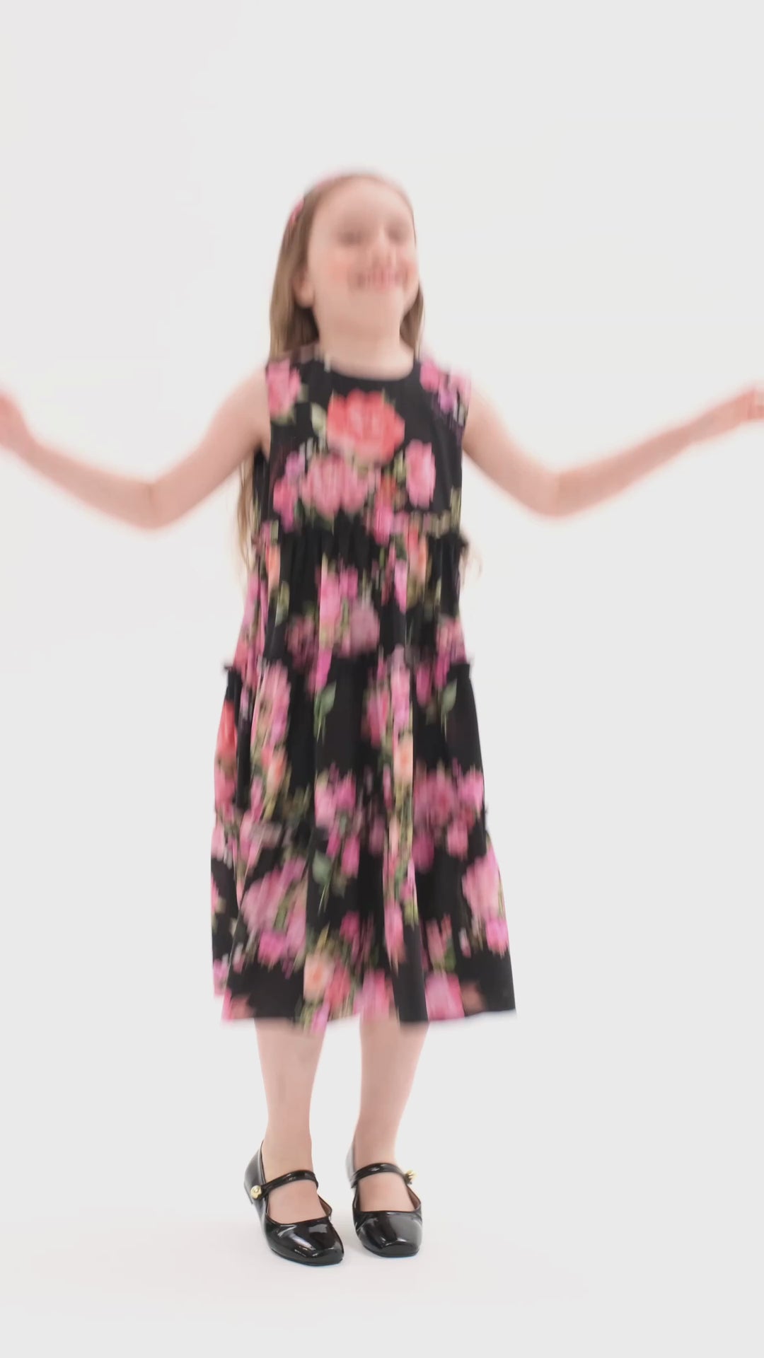 ALISA, A CHILDREN'S DRESS IN BLACK ADORNED WITH MEDIUM-SIZED PINK FLOWERS.